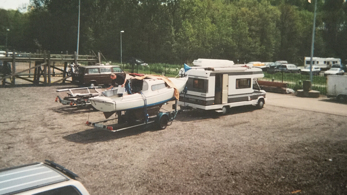 A car and boat trailer parked side by side, ready for a day of boating on the water.