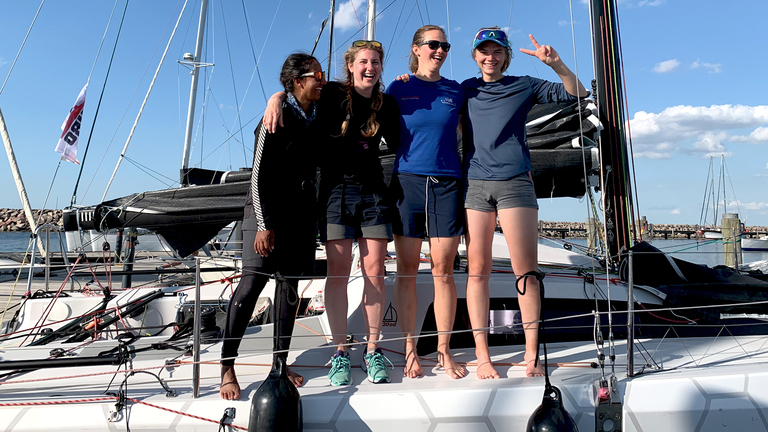 Team photo of a successful all female sail racing team posing on their sailboat