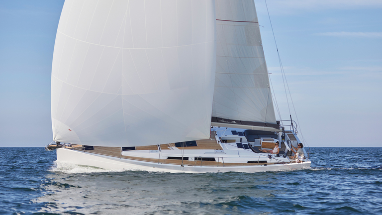 Hanse yacht sailing on open ocean with main sail and gennaker