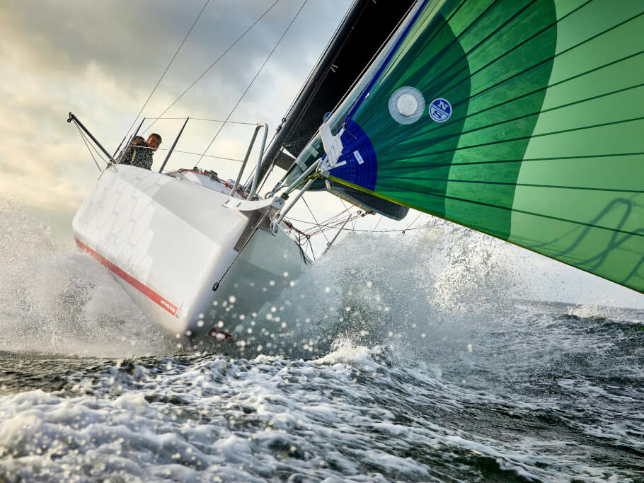 View from the front of white yacht with green sails
