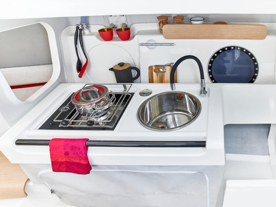 Dehler 30 one design galley | The well-equipped galley includes a gas stove, sink with flexible tap and foot pump, and room for standard-sized coolers. | Dehler