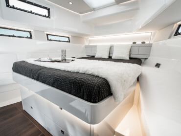 Fjord 48 open Interior view owner´s cabin | Island double berth with indirect lighting, painted furniture, noce nero flooring, opening hatches, opening coachroof portholes, opening portlights | Fjord