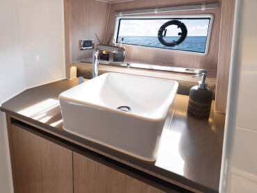 Baño con luz natural, lavabo y mucho espacio de almacenamiento en el yate a motor SEALINE C335