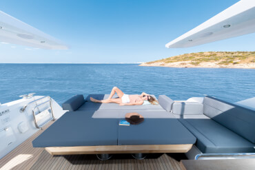 Sealine C530 cockpit | Fold down the backrest of the stern bench to create a lie-down area at the cockpit table. When the table is lowered, both surfaces combine into a huge sunbathing area. | Sealine