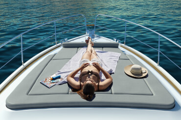 晒太阳的人在机动游艇的太阳垫上放松。