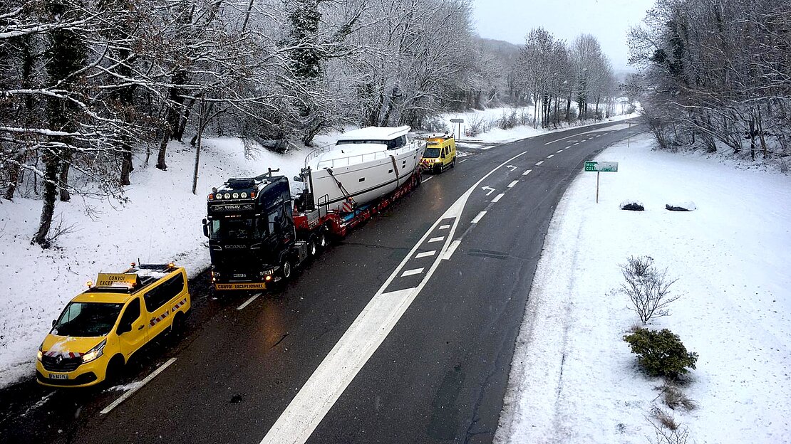 Yacht travels by road over snow covered landscape