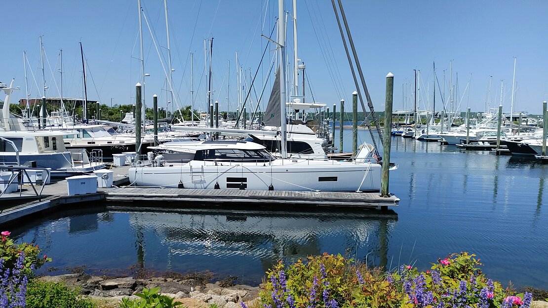 New yacht sits at anchor in harbor after being transferred to the other side of the world