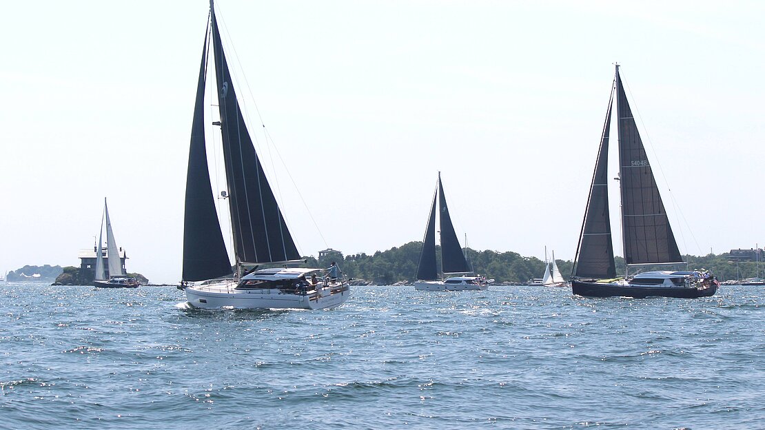 在豪华蓝水游艇锦标赛上航行的一群帆船