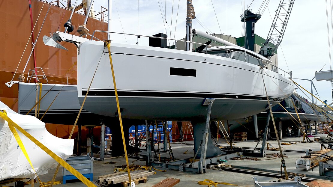 Dry docked yacht waits for transport in shipyard